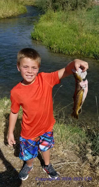 Boy with fish, creek behind
